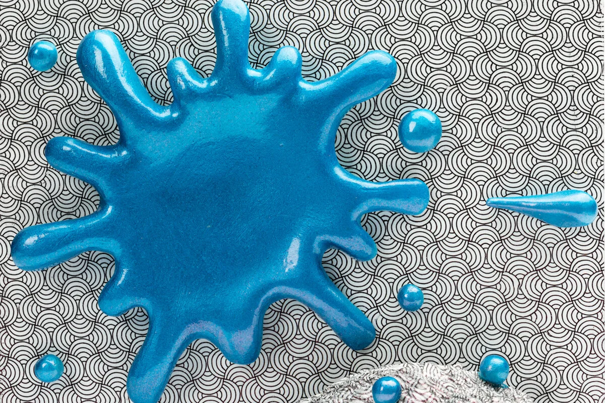 unique ceramic and mixed media sculpture by ceramicist Jennifer McCandless of hedgehog hiding in op art black and white pattern with blue splatters at Soapbox Arts Gallery