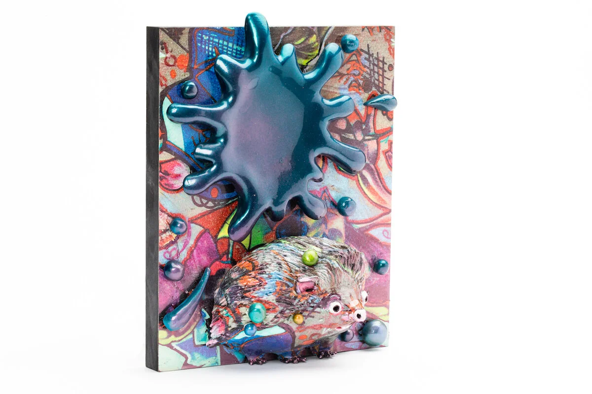 unique ceramic and mixed media sculpture by ceramicist Jennifer McCandless of hedgehog hiding in graffiti art black and white pattern with blue splatters at Soapbox Arts Gallery