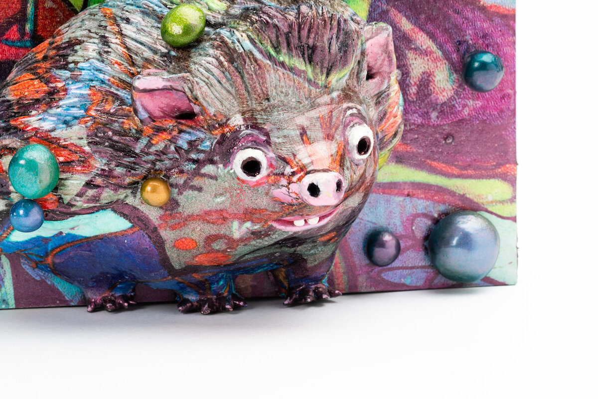 unique ceramic and mixed media sculpture by ceramicist Jennifer McCandless of hedgehog hiding in graffiti art black and white pattern with blue splatters at Soapbox Arts Gallery