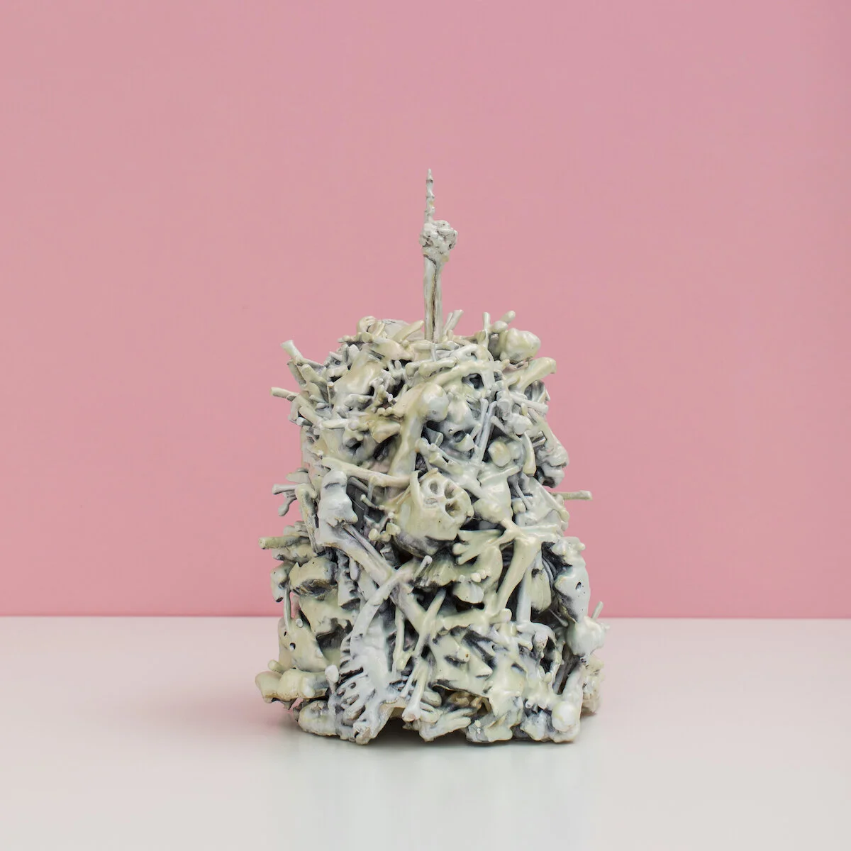 original hand built and painted ceramic sculpture by Jennifer McCandless of a pile of bones with arm sticking out of the top giving the middle finger, available exclusively through Soapbox Arts