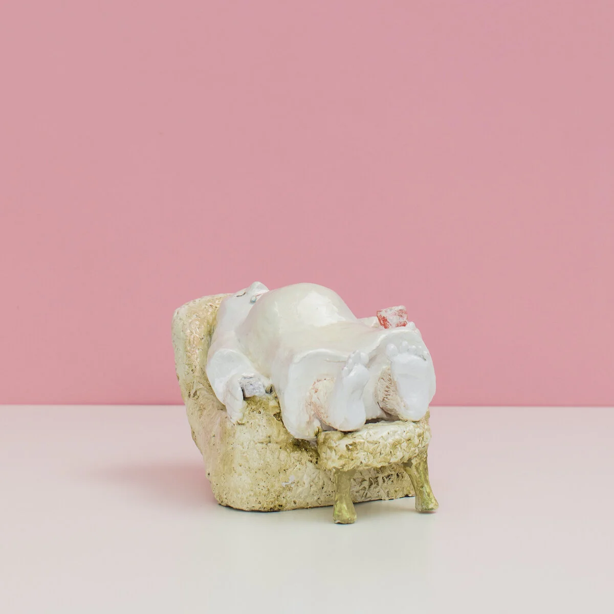 humorous hand built and painted ceramic sculpture of a ghost laying in an armchair with a can of soda  by Jennifer McCandless available through Soapbox Arts