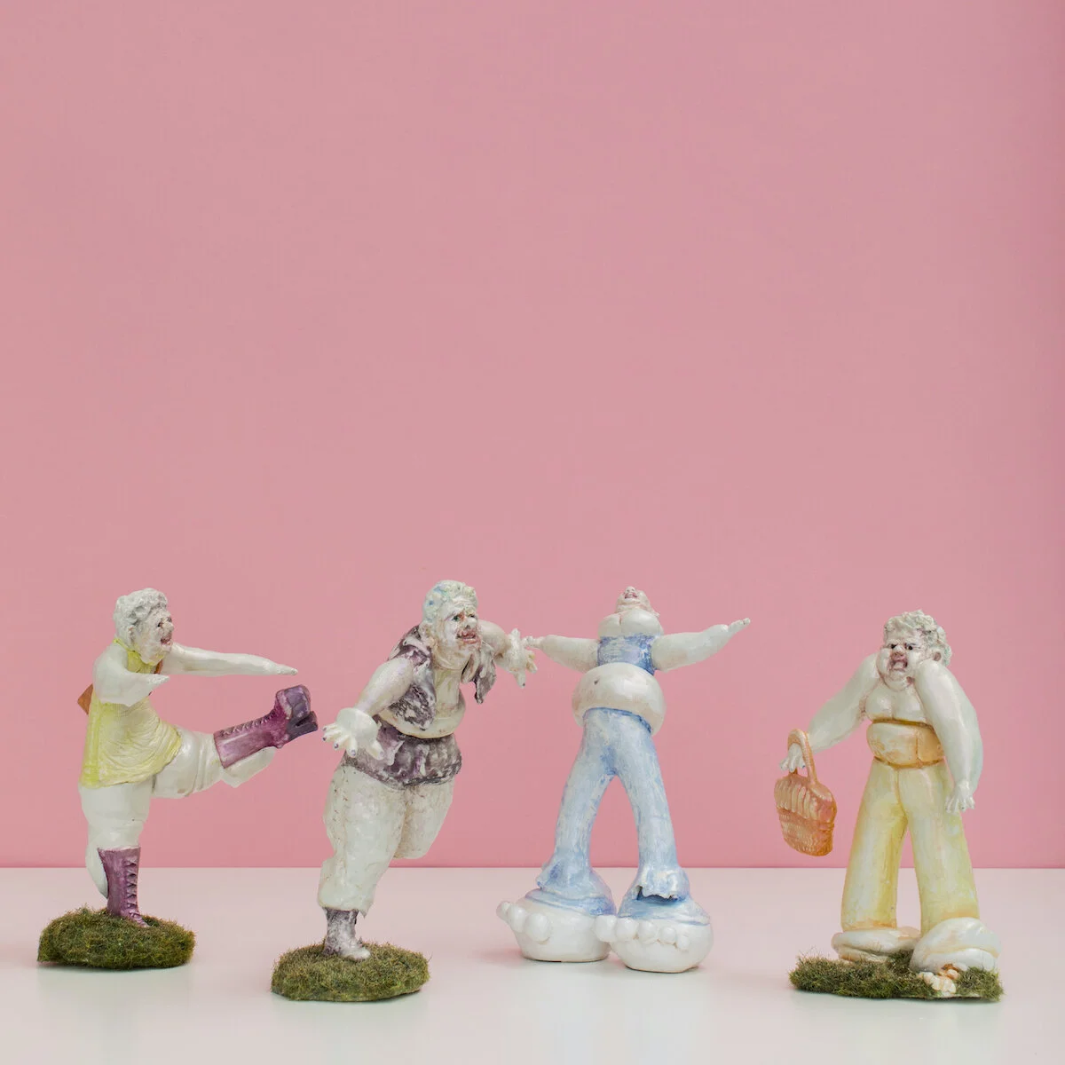 humorous hand built and painted ceramic sculptures of small women squeezing into tight fitting clothing in flailing positions by Jennifer McCandless available through Soapbox Arts