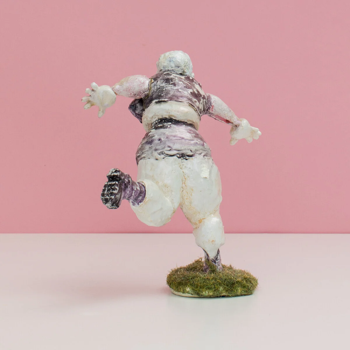 humorous hand built and painted ceramic sculptures of small women squeezing into tight fitting clothing in flailing positions by Jennifer McCandless available through Soapbox Arts