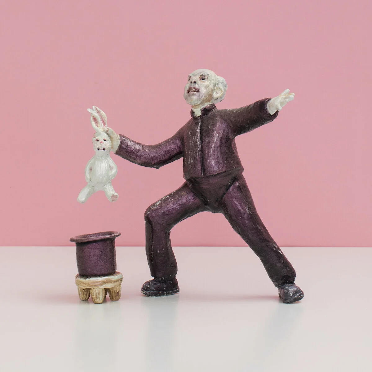 humorous hand built and painted ceramic sculpture of a man dressed as a priest pulling a rabbit out of a hat by Jennifer McCandless available through Soapbox Arts