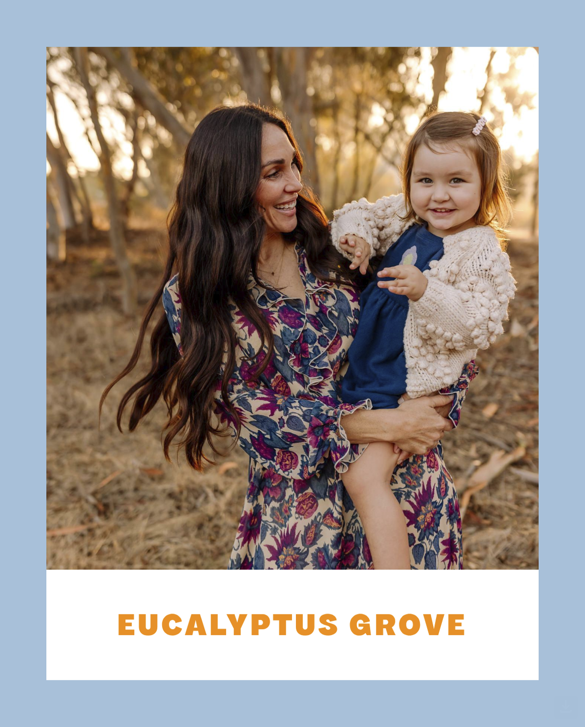 A woman holding a smiling little girl in an outdoor setting with trees and golden sunlight, labeled 'EUCALYPTUS GROVE'.