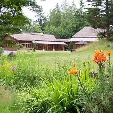 yoga retreat venue set in fields and woodland with orange flowers in the foreground