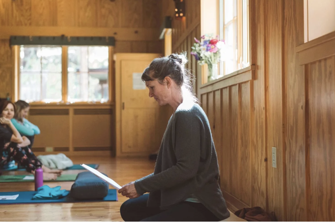 joanna dunn yoga teacher kneeling in studio