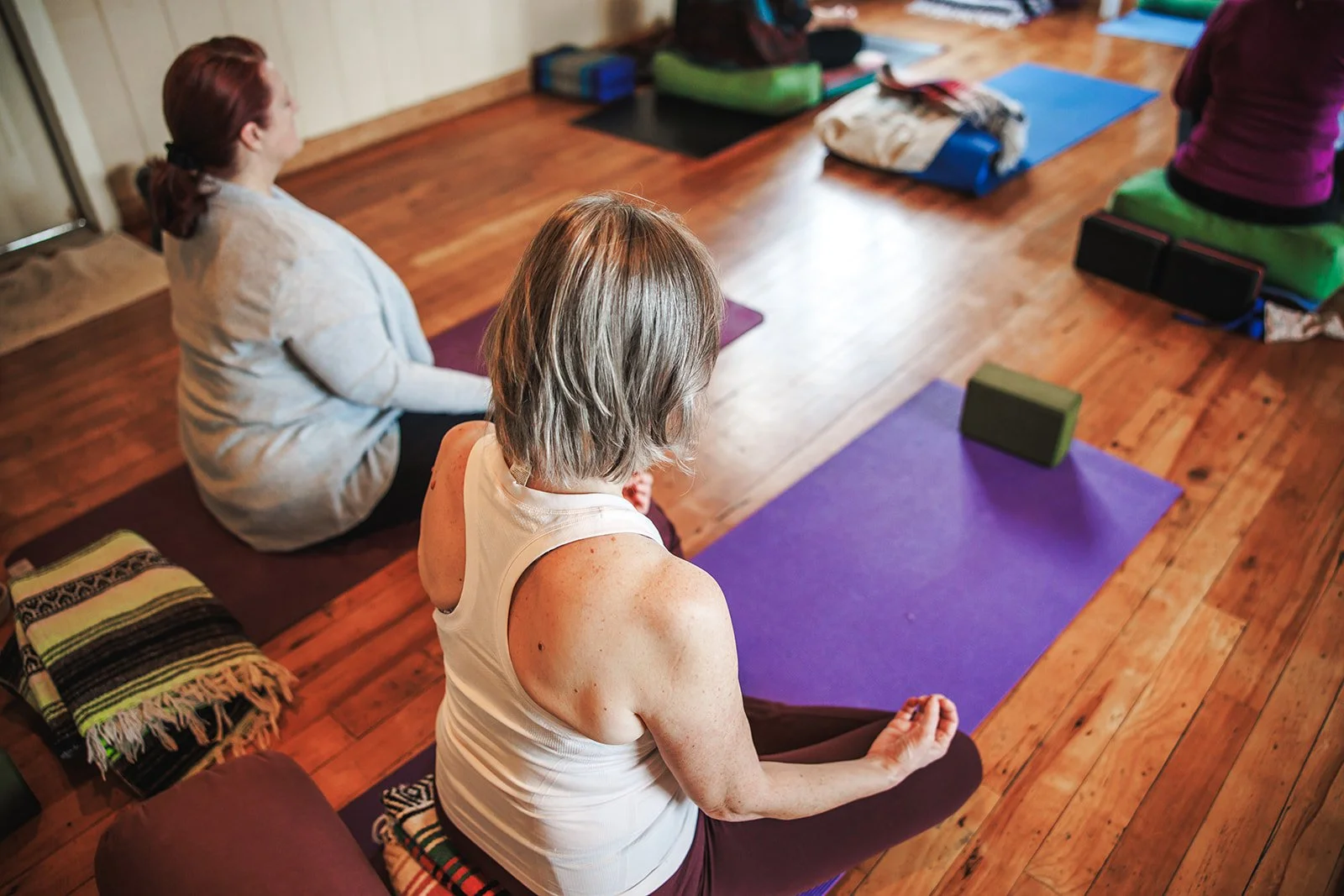 women yoga retreat participants sitting on a mat