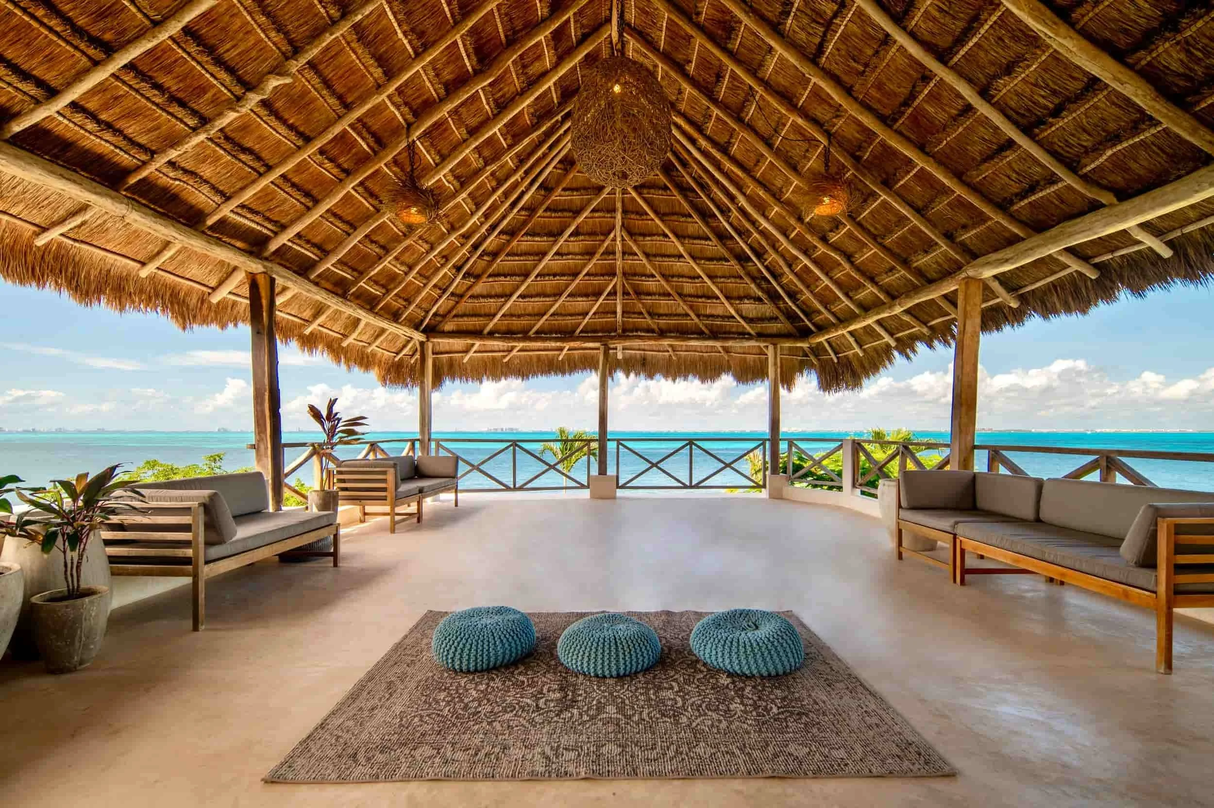 mexico yoga retreat beach hut with blue cushions and rattan style furniture for yoga practice