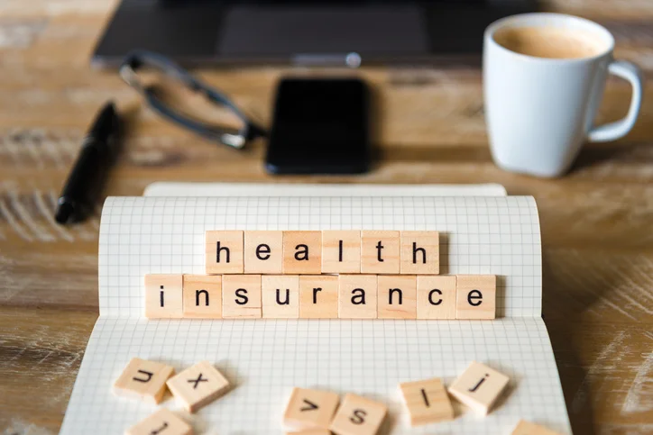 Wooden tiles that spell out "health insurance."