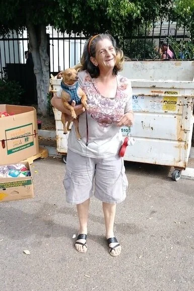 CCDSD’s “Gate Monitors,” Mary and her pet Chihuahua. Her infectious smile is a familiar site at our Downtown location’s monthly distribution.