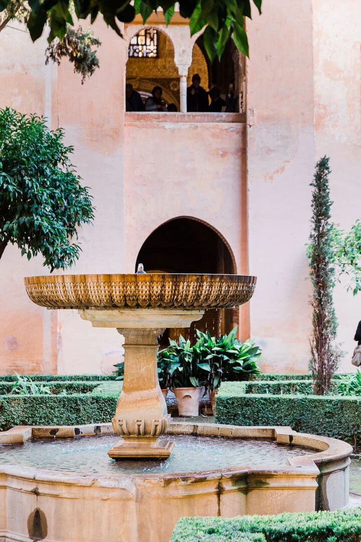 Fountain inside a pink courtyard of the Alhambra palace in Granada, Spain.
