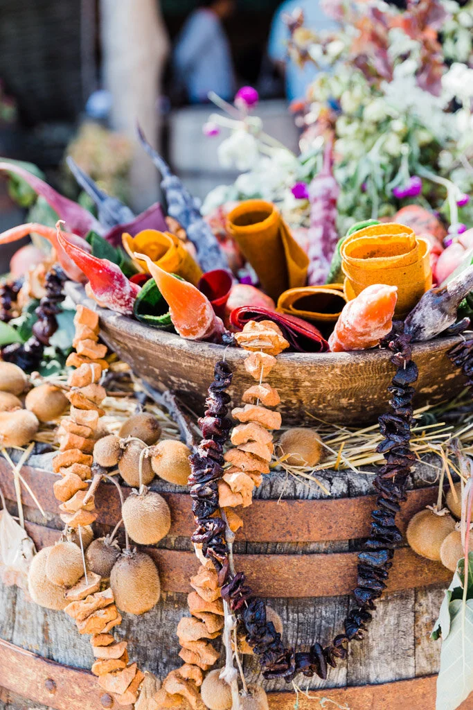 Georgian dried fruits, nuts, churchkhela in a bowl on top of a wine barrel.
