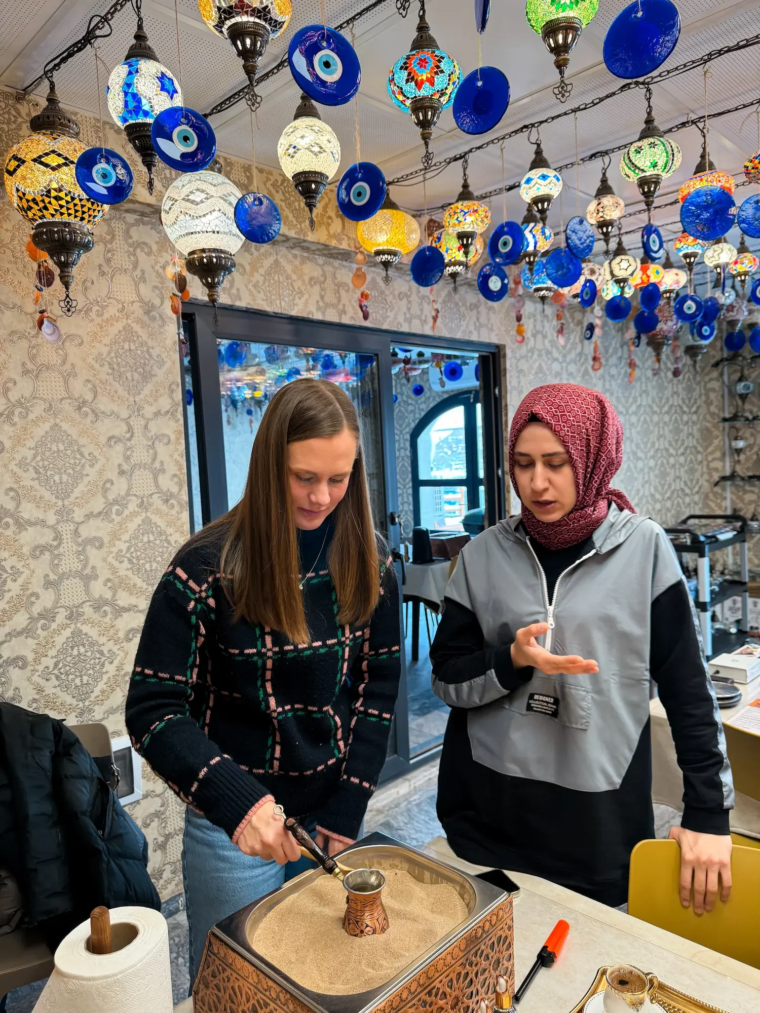 Woman learning to make Turkish coffee in hot sand in a class in Türkiye
