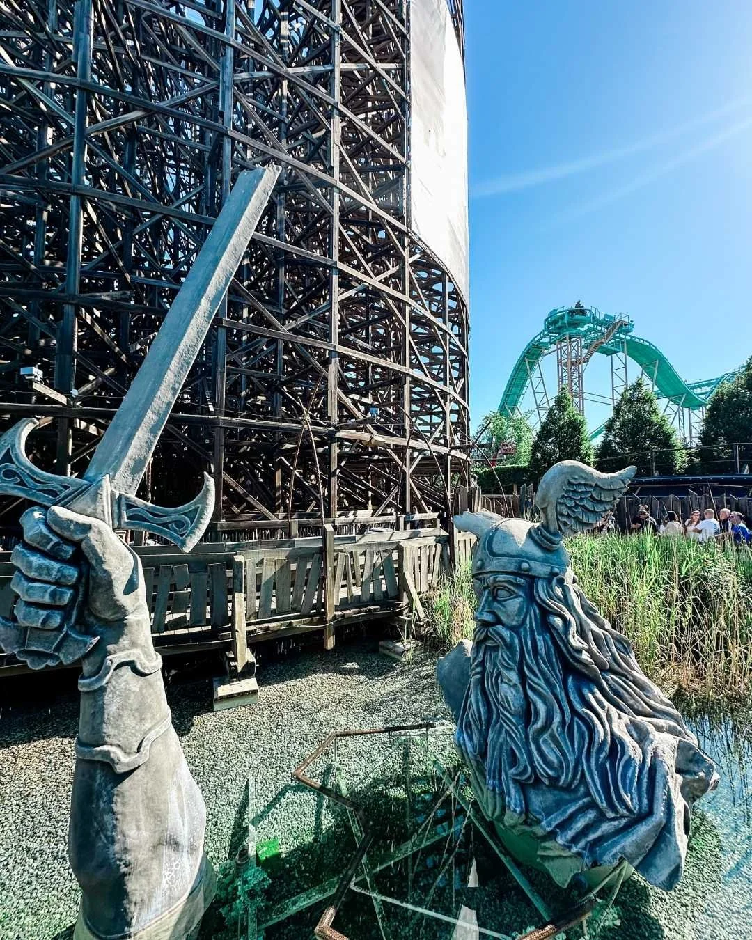 Large viking statue coming out of the ground with roller coasters in the background at Europa Park, Germany