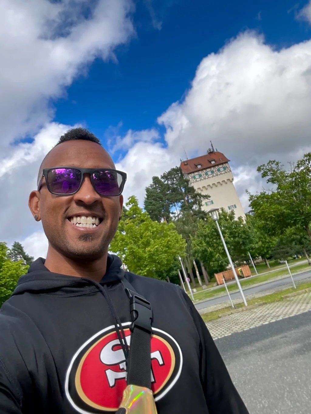 Man in sunglasses smiling with German building in the background