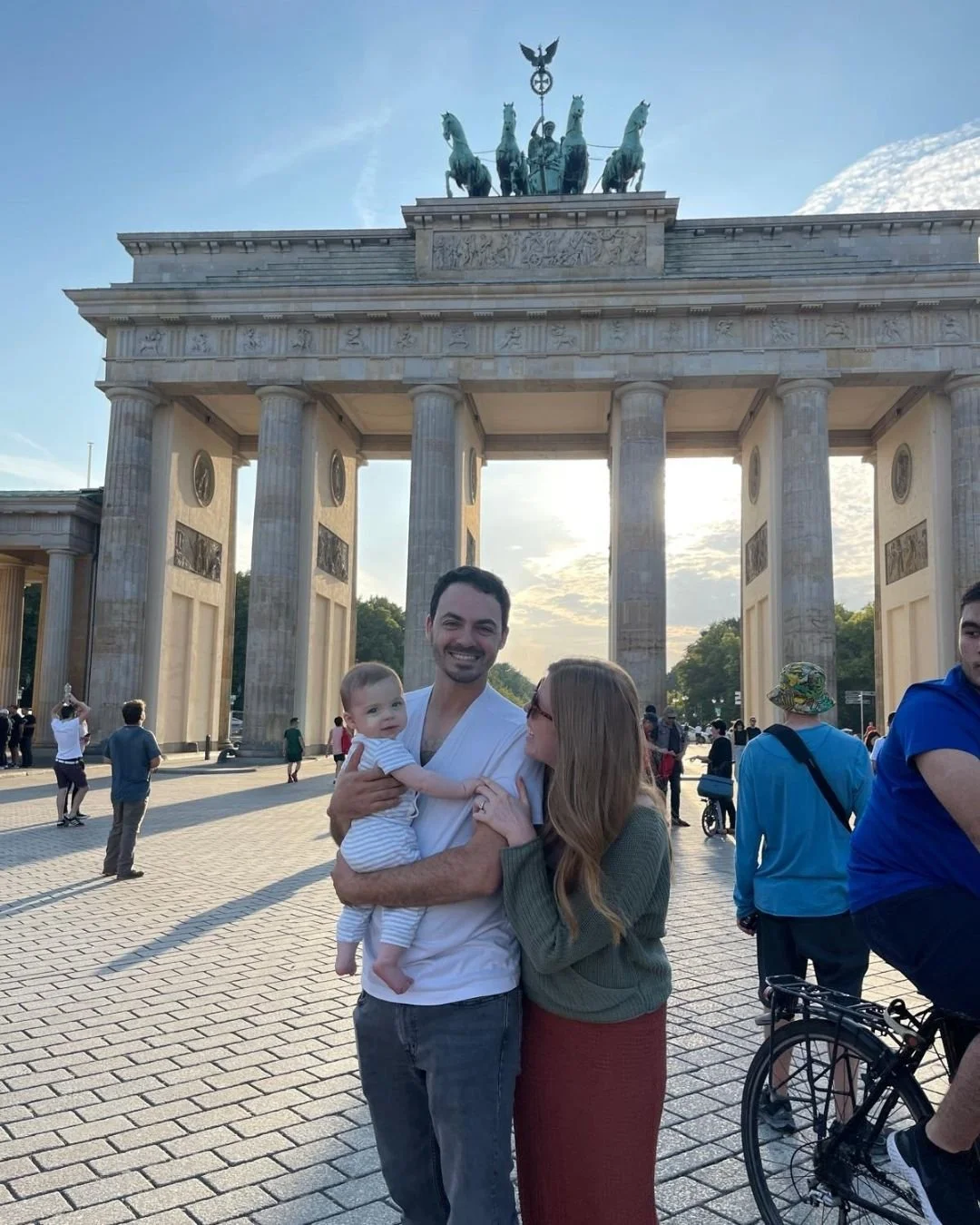Woman looking at man holding a baby in front of the Brandenburg Gate in Berlin Germany