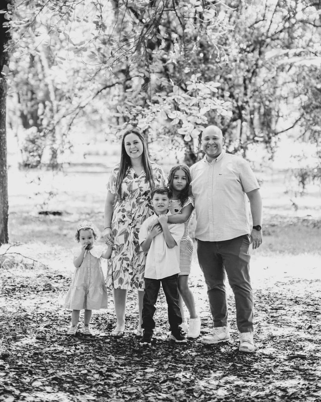 Black and white family photo of mom, dad, and three children.