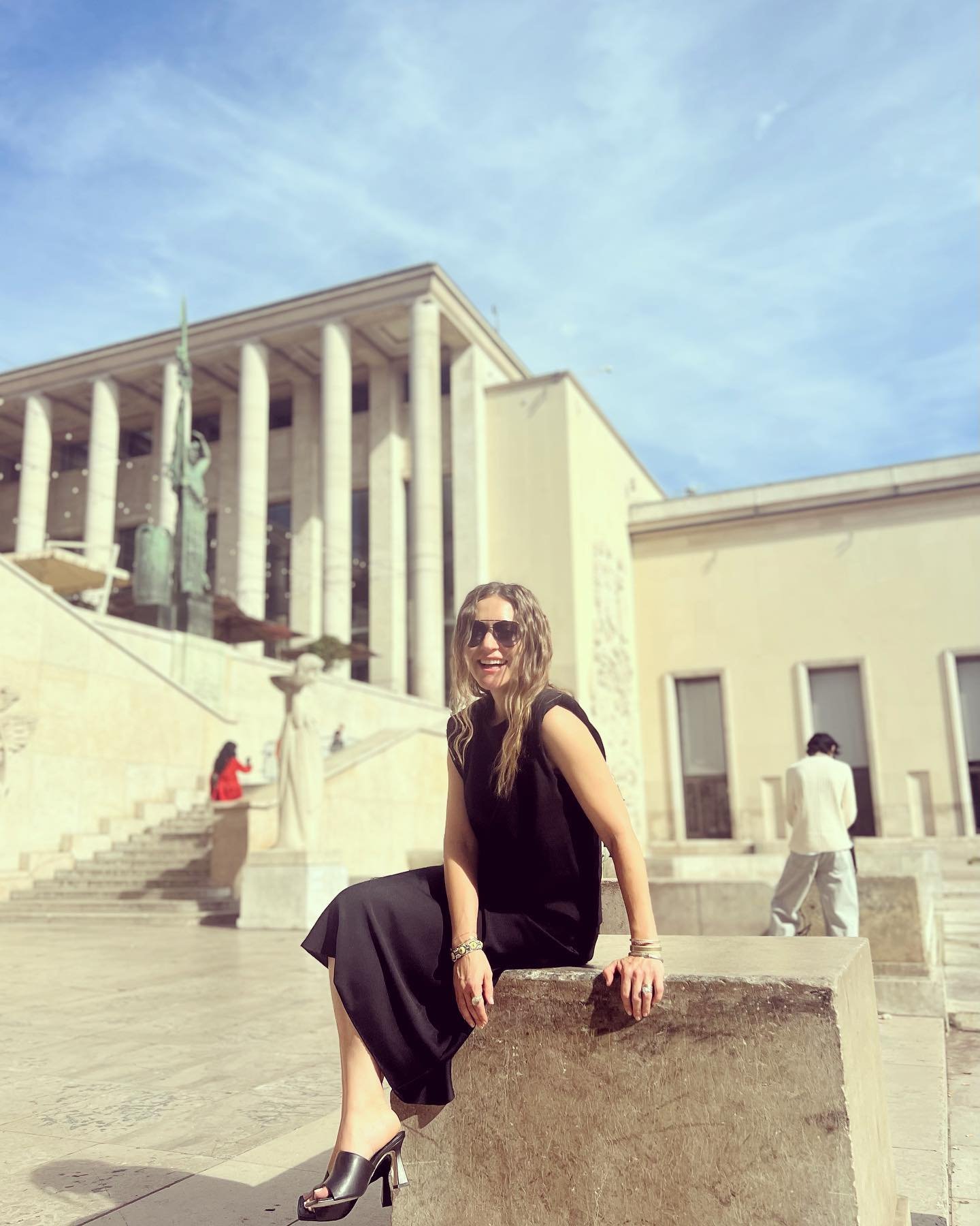 Woman in black dress sitting on a concrete block in Paris