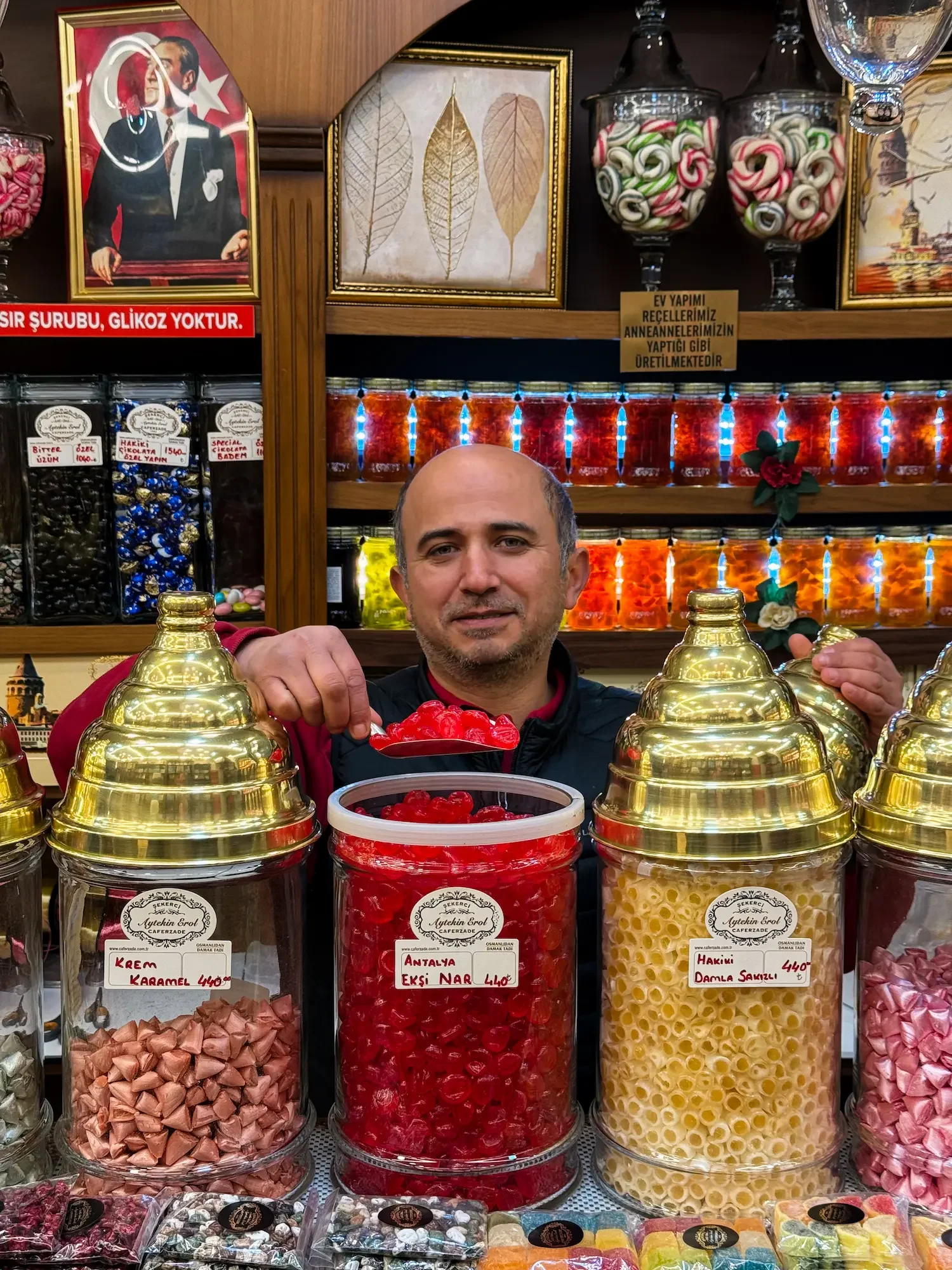 Candy shop in Istanbul, shop owner is holding a scoop of candy on Istanbul food tour