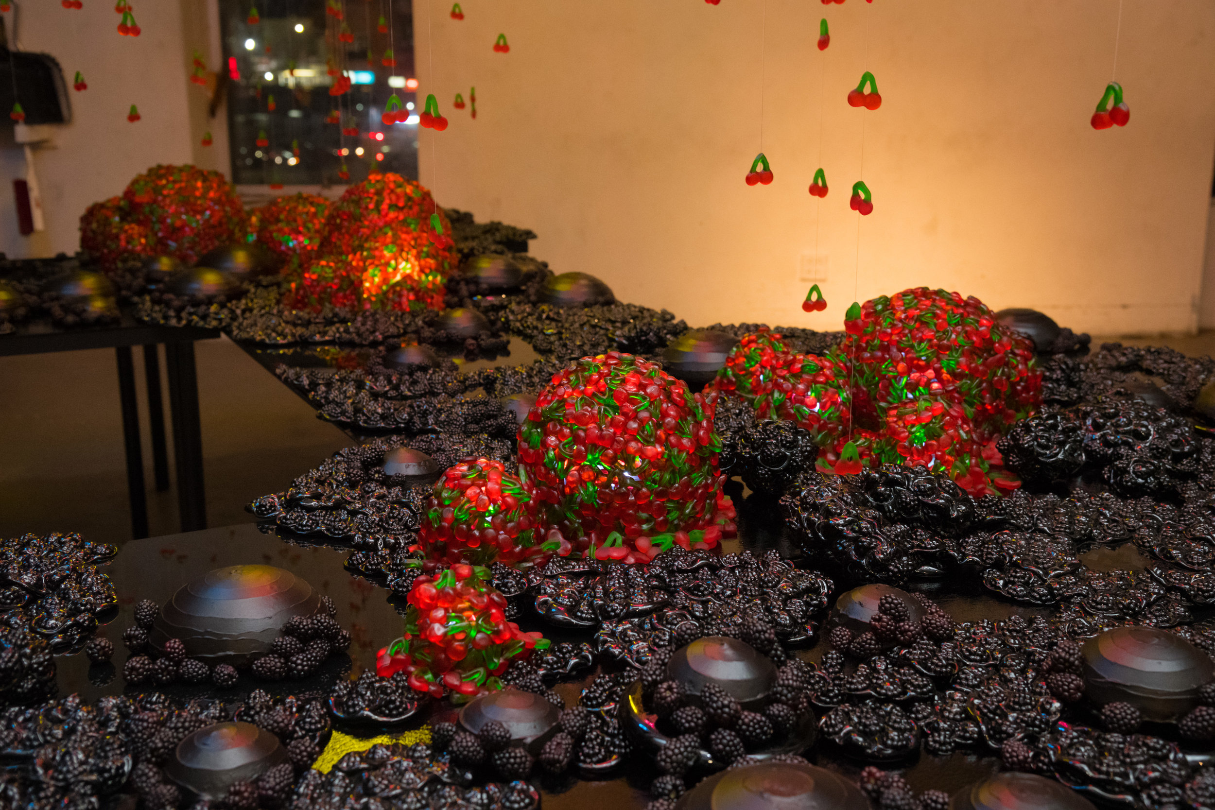 Cast glass black raspberry platters with 40 red velvet cakes, gummy cherry domed LED lights and black berries.
