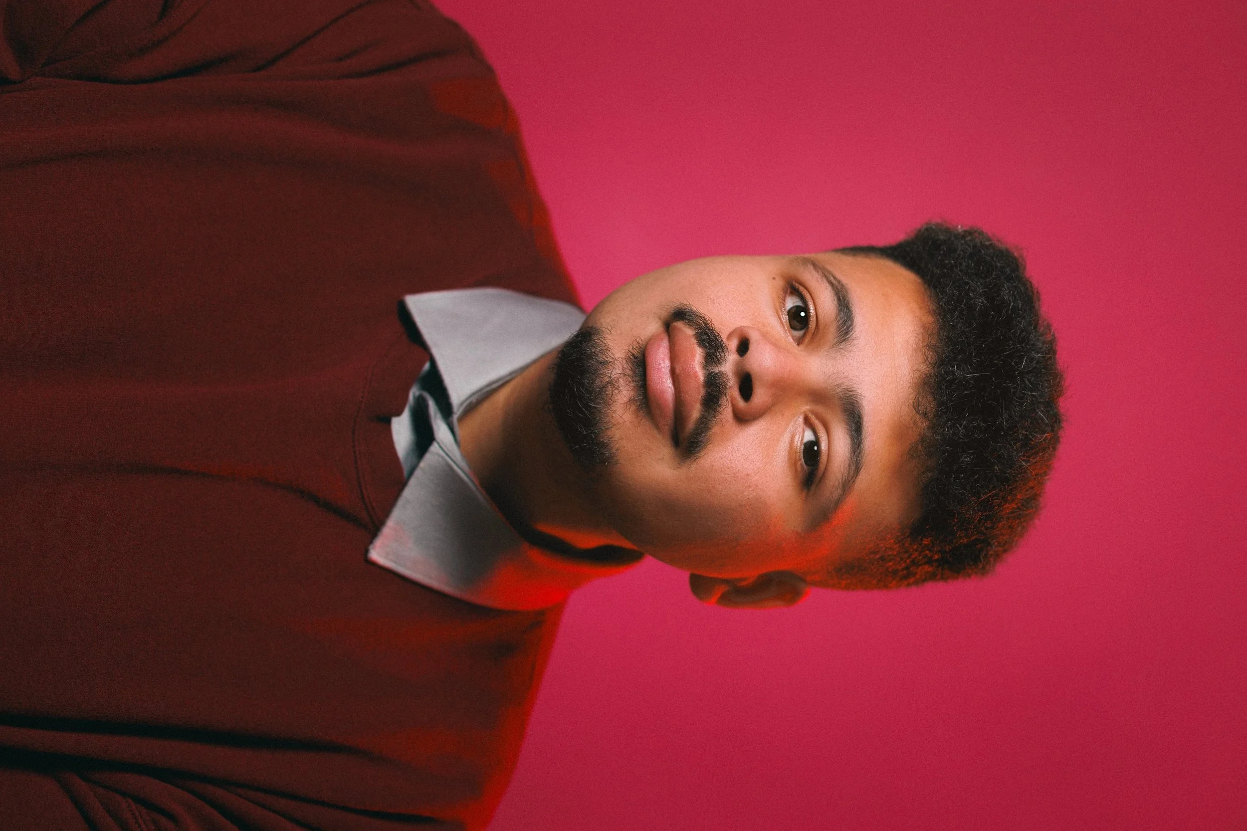 Headshot of an author against a pink backdrop