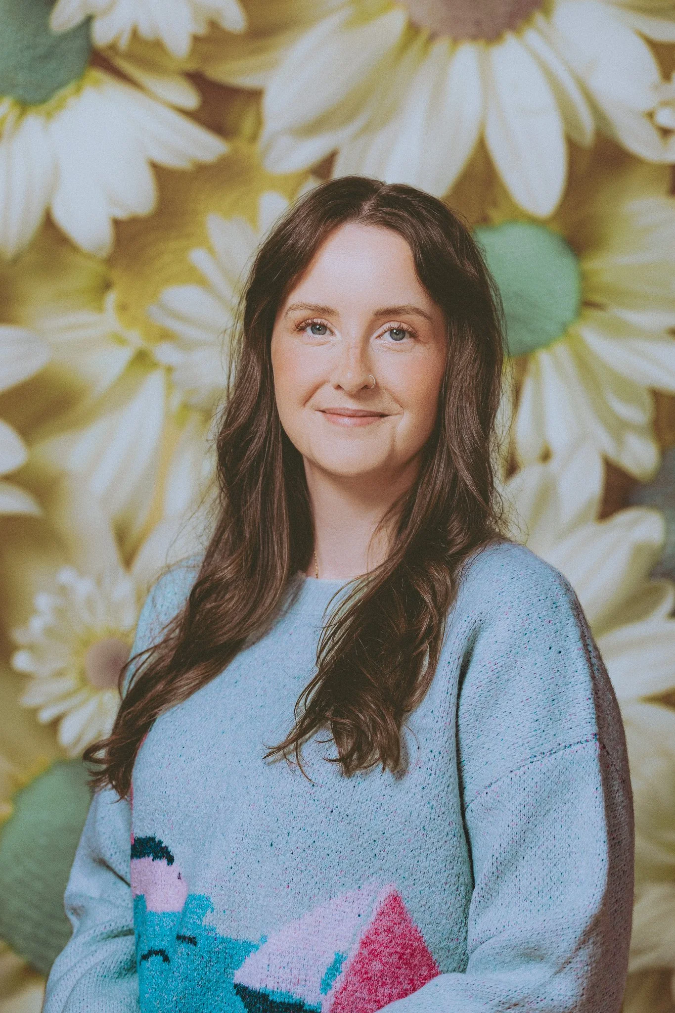 Headshot of a director against a sunflower patterned backdrop