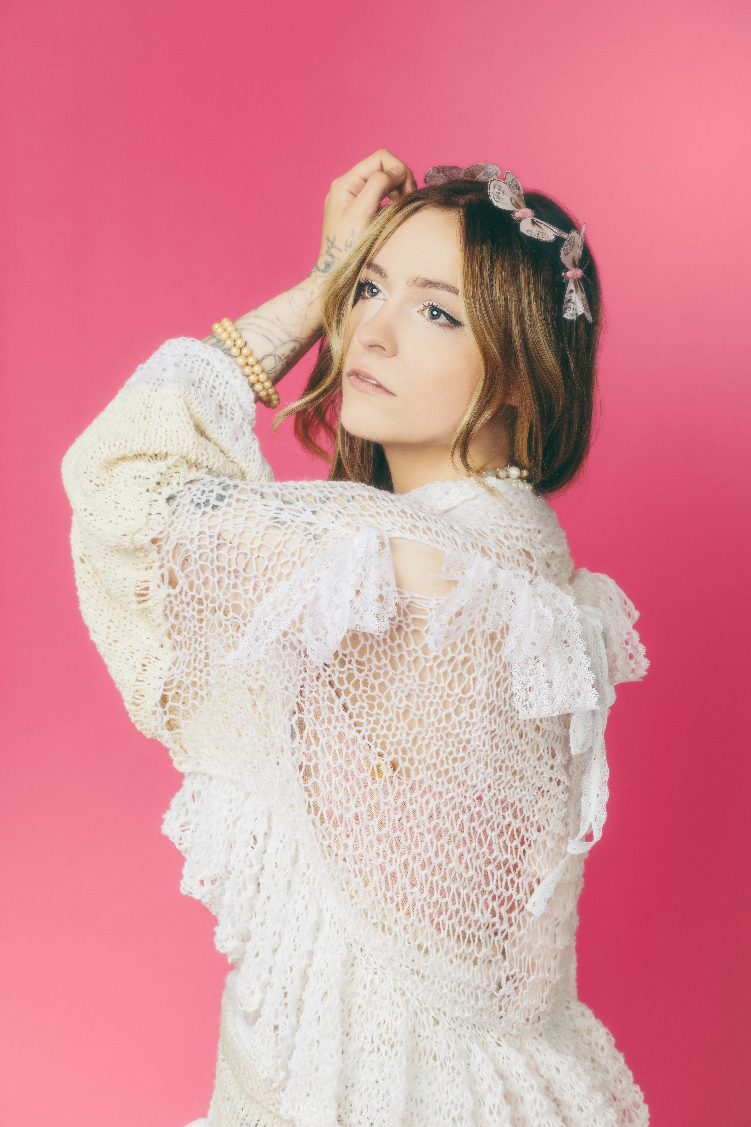 Ethereal studio portrait of a model against a pink backdrop
