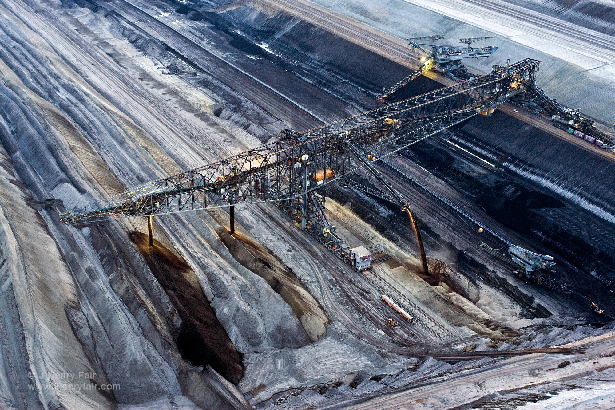  Nighttime mining, conveyor bridge moving overburden above mining trench to other side. 