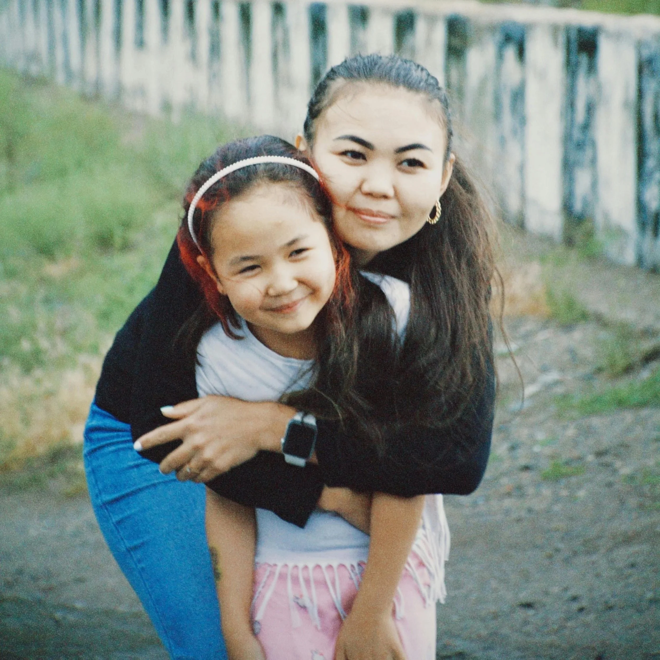 Mom hugs daughter who is smiling