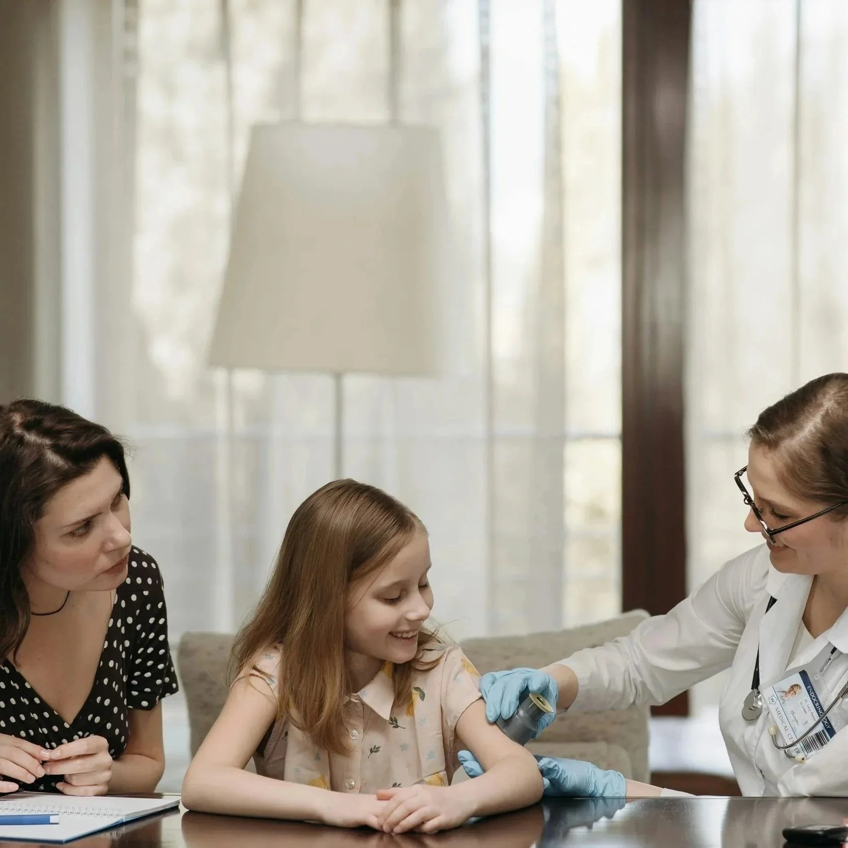 Doctor smiles at young girl and her mom