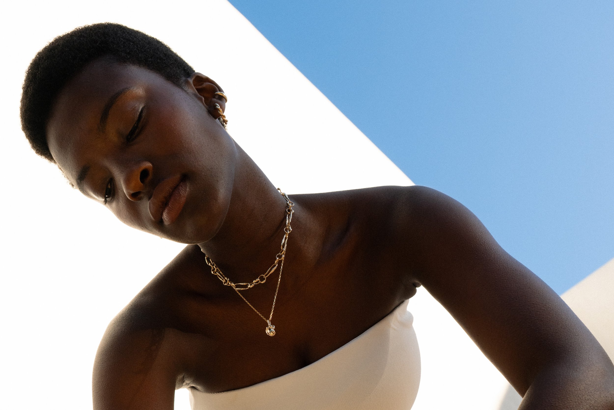 Anna wears the Helix Hoops with the Metanoia Handmade Chain and the Soft Body Venus Necklace. All in solid recycled 14k gold.