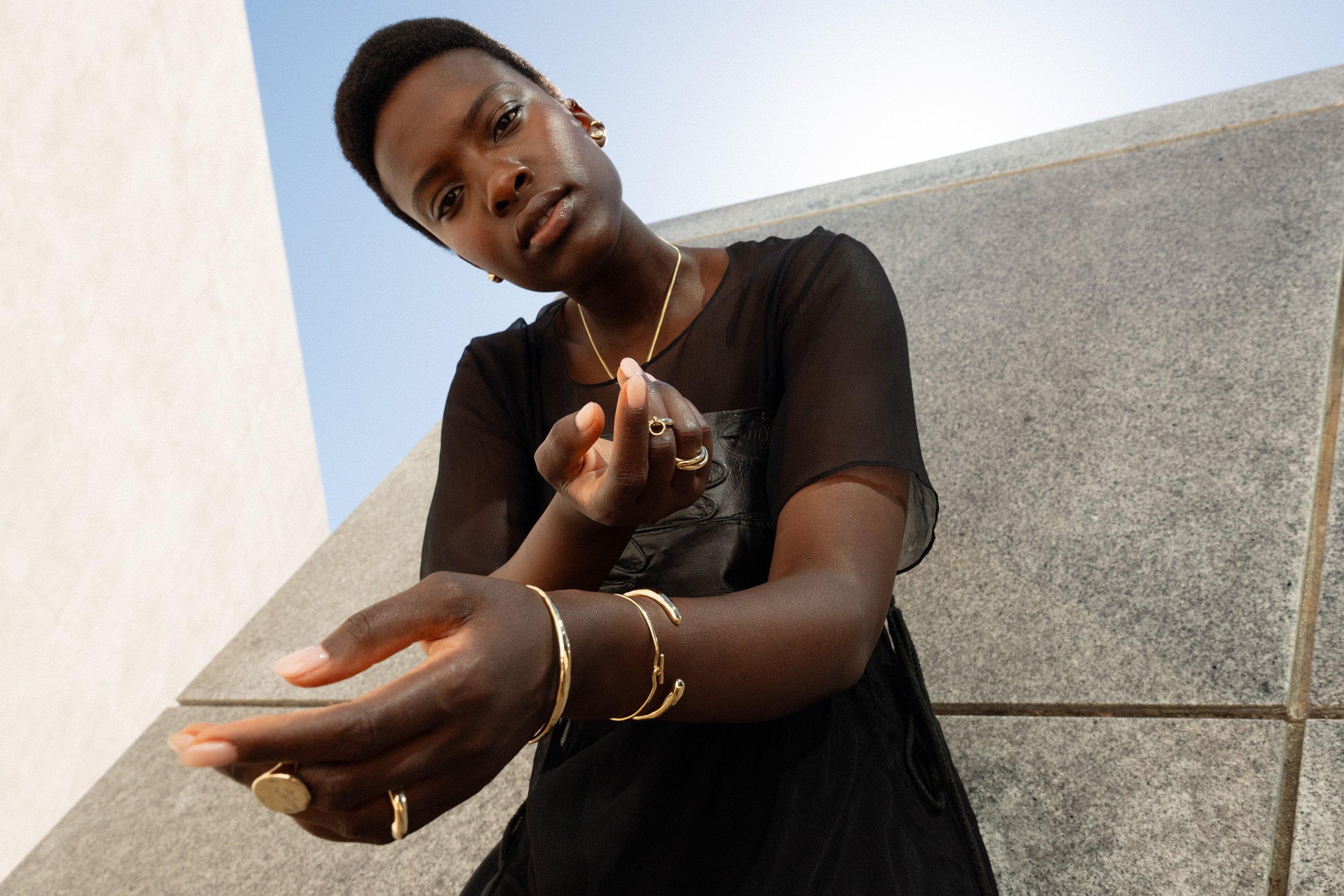 From top: Anna wears the Sibyl Ear Cuff, Horus Studs with marquise diamonds, the Interconnection Trio Ring, Interdependence Ring, the Inverse Cuff, Orbit and Portal Bracelets, the Persephone Ring and Ra Signet Ring.  