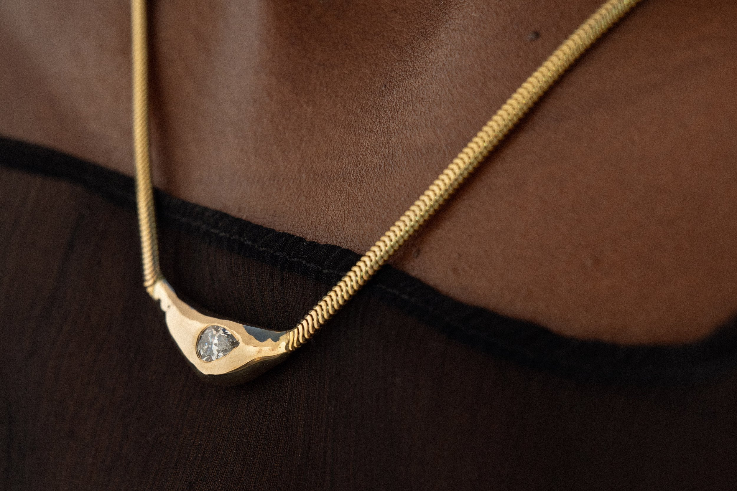 The Where the Light Come Through Necklace, featuring a reclaimed pear cut diamond.