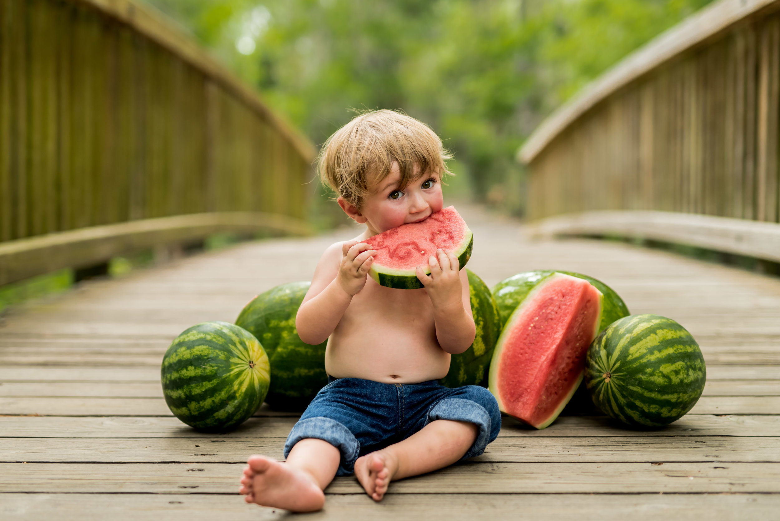 18 month old little boy eating watermelon in the summer with junebug photography studio in manhattan, ks