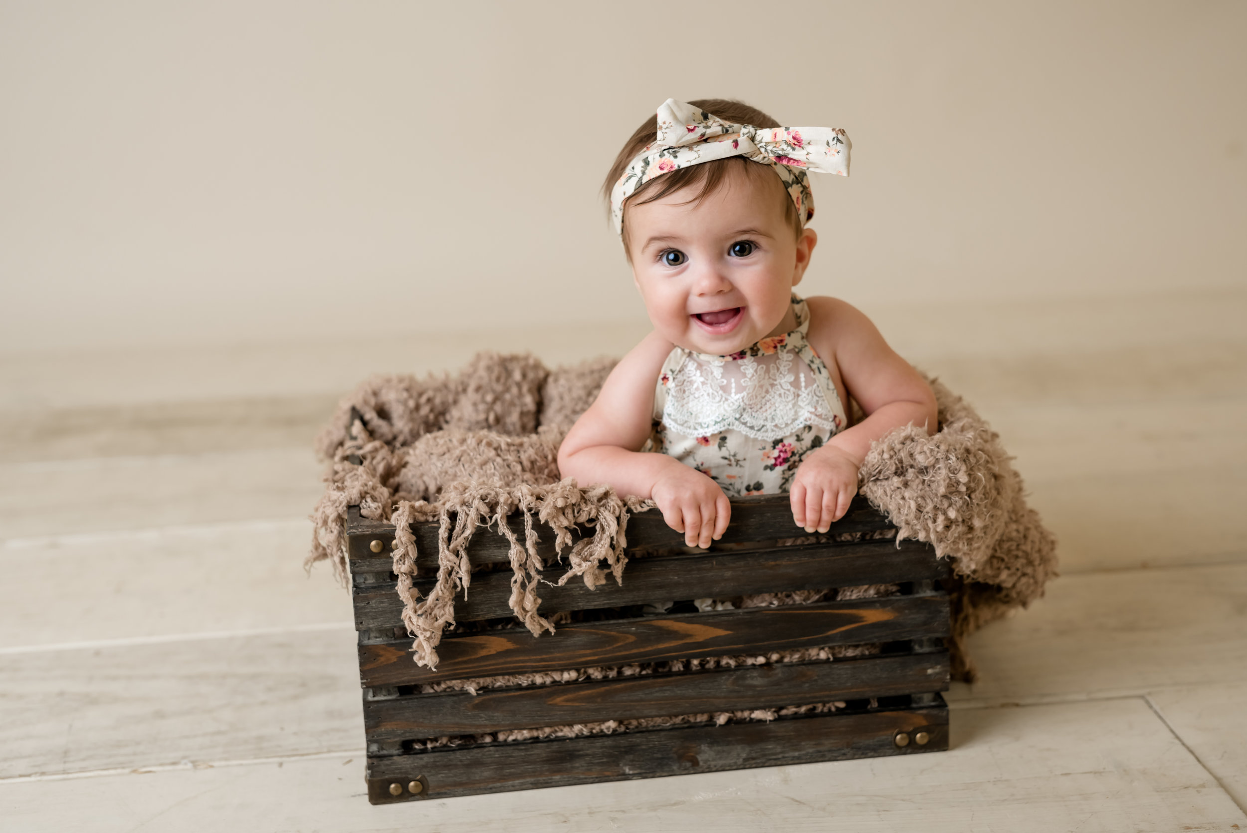 baby girl in a wooden crate with junebug photography studio in manhattan, ks