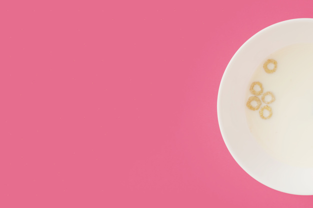 corn-cereal-rings-floating-on-the-milk-in-the-white-bowl-on-pink-background_23-2147872668.jpg