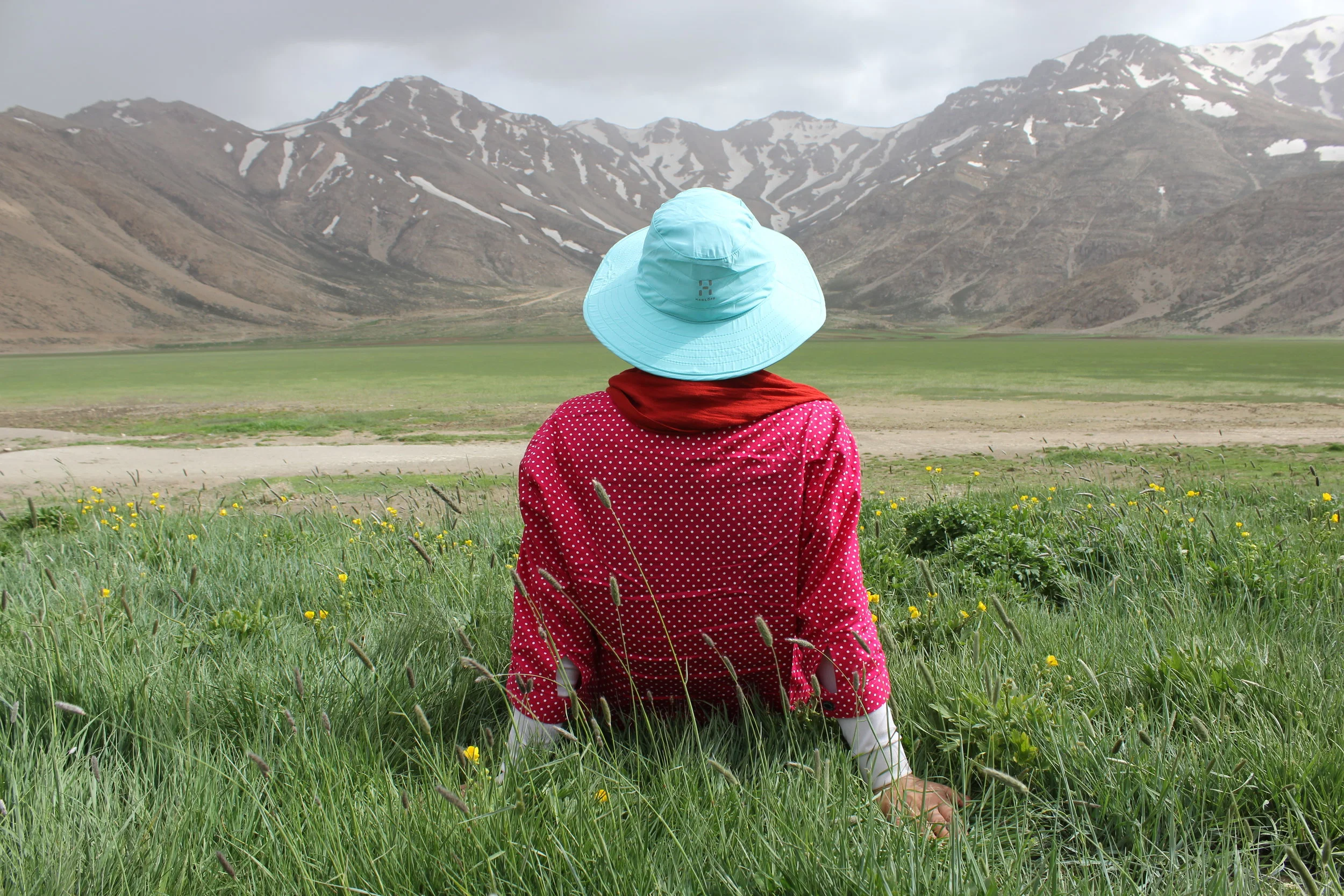 Woman enjoying view of mountains in a meadow. Free from anxiety. Tipi helps.