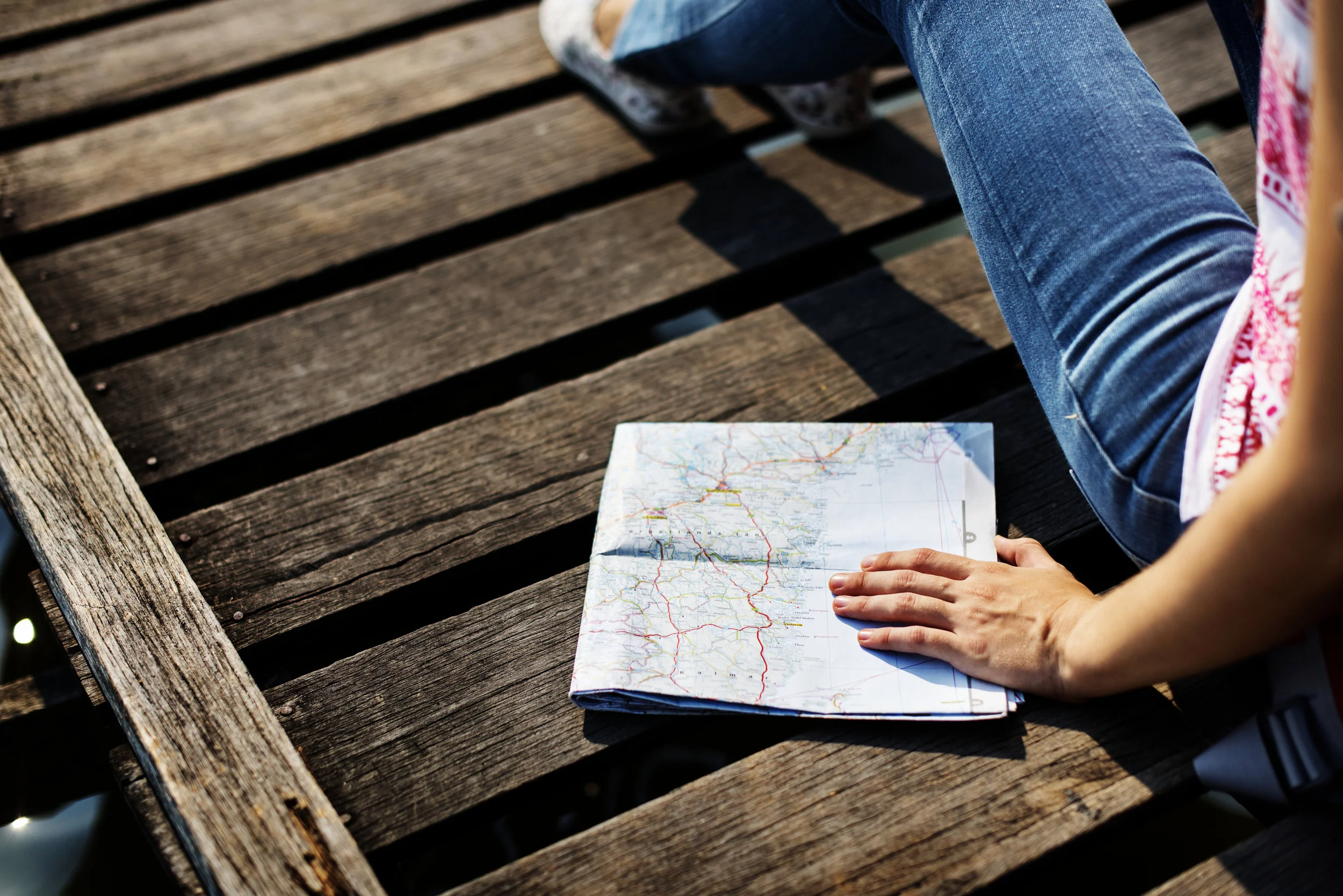 Woman with a map on a dock. Plan to live life fully and overcome fear, anxiety, phobias. Increase self confidence.