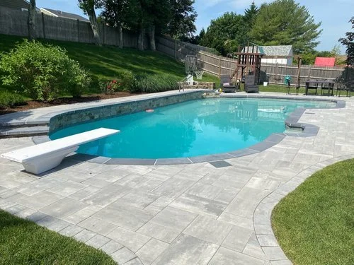 A Fully Customized Pool Deck May be Achieved with the Help of a Retaining Wall in the Wellesley, MA Area
