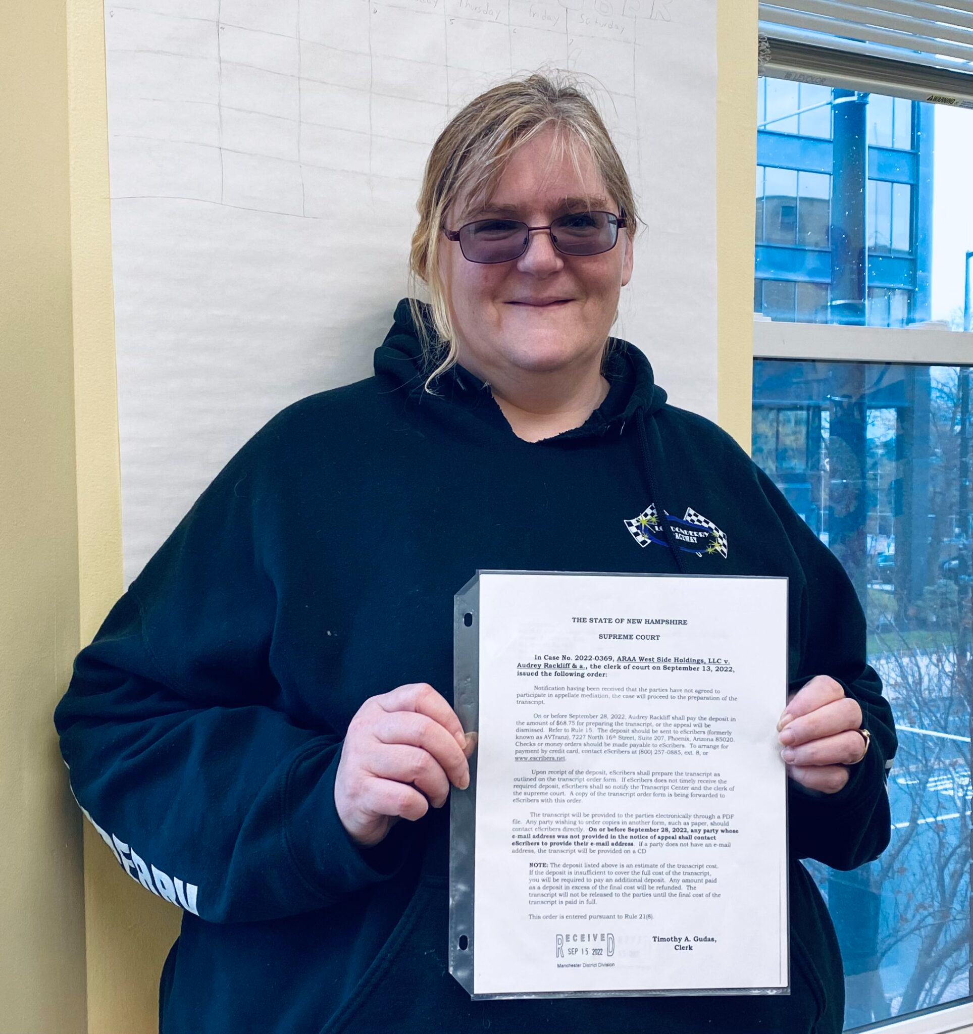   Audrey Rackliff holds a copy of the NH Supreme Court ruling which vacated a lower court’s decision that would have evicted her from her home of eight years. Photo/Pat Grossmith  