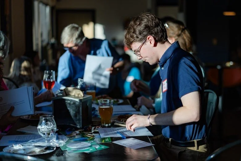 James Kelly reads a piece of paper on the table during the Publisher’s Crawl at Lithermans Limited Brewing Company on June 9, 2026 in Concord. Credit: ALEX MILLER / For the Monitor 