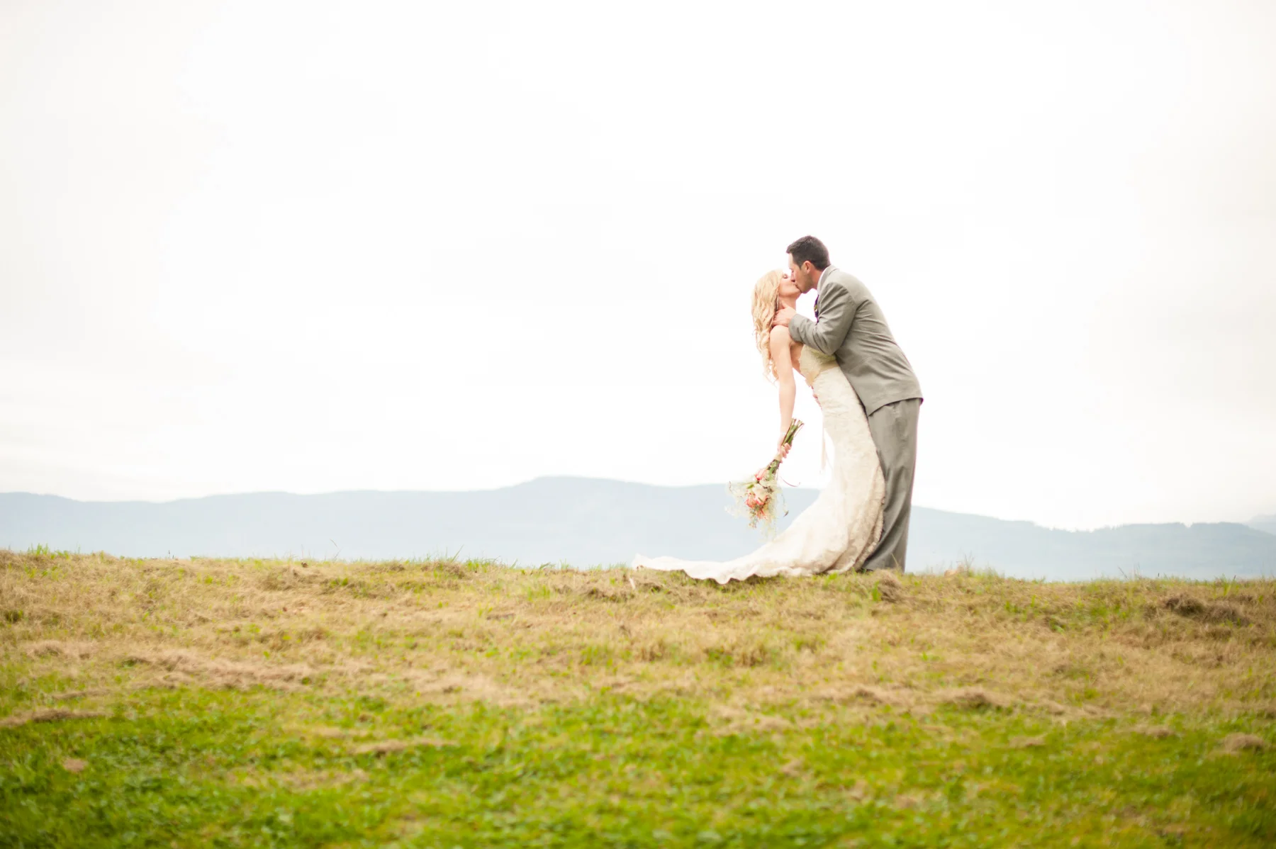 bride and groom kissing on the horizon