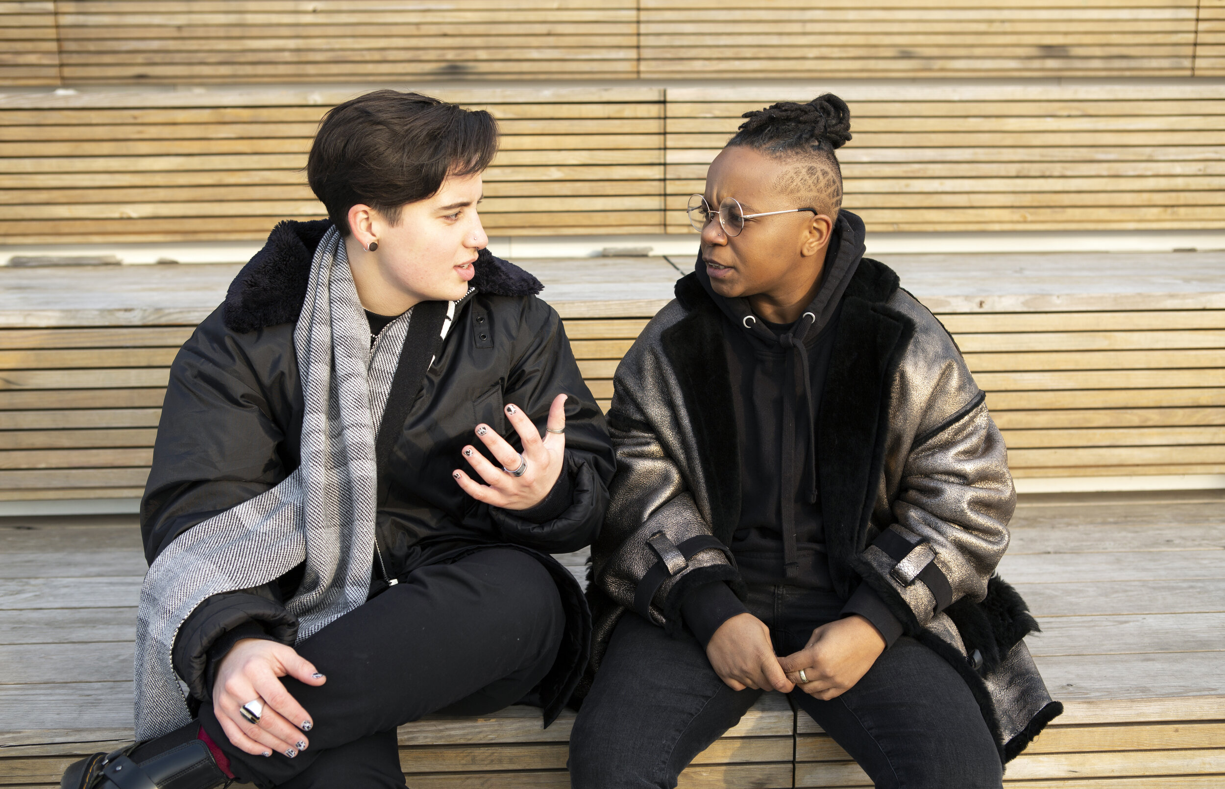 Two transmasculine people sitting in conversation.jpg