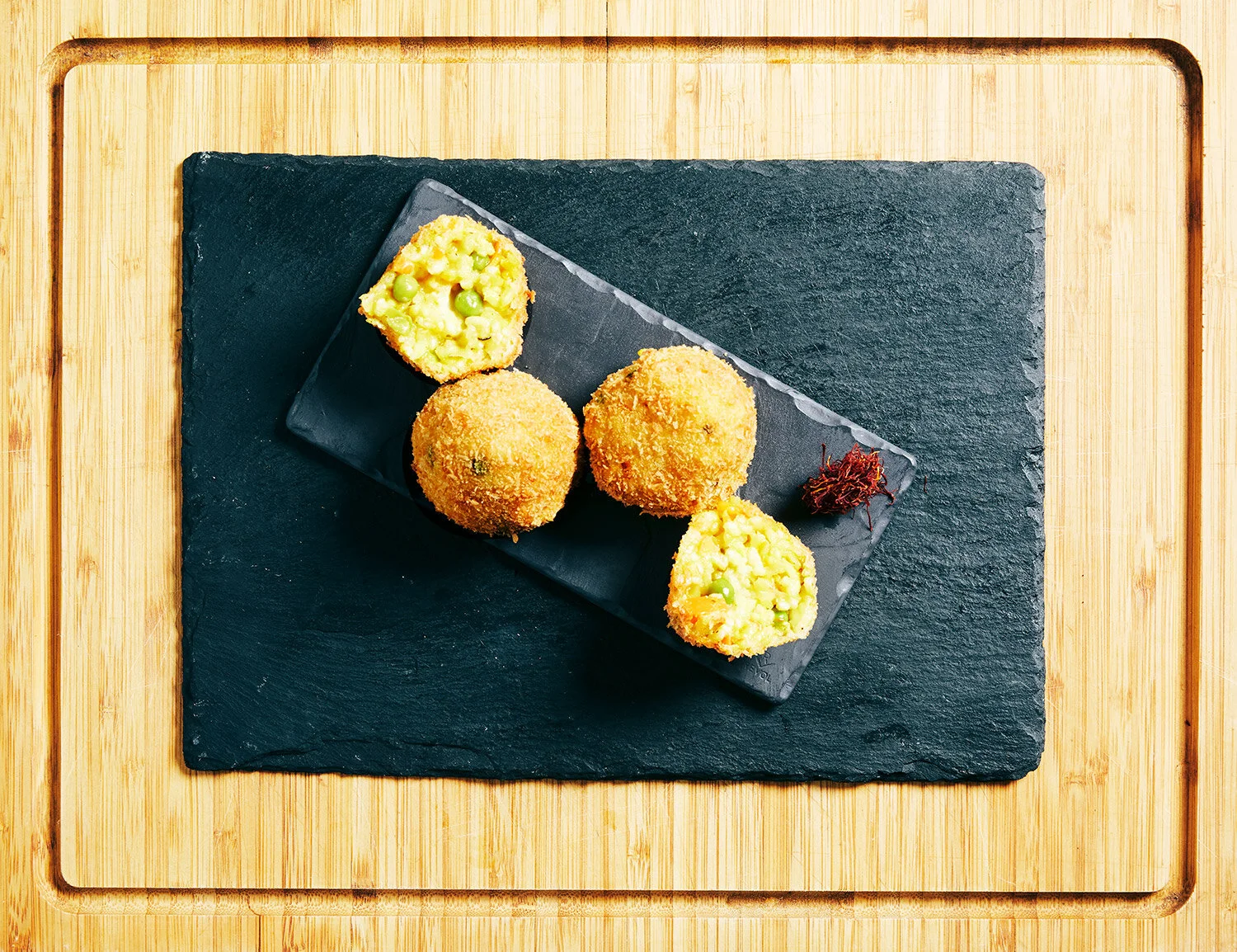 Classic Arancini served on a slate on a wooden board