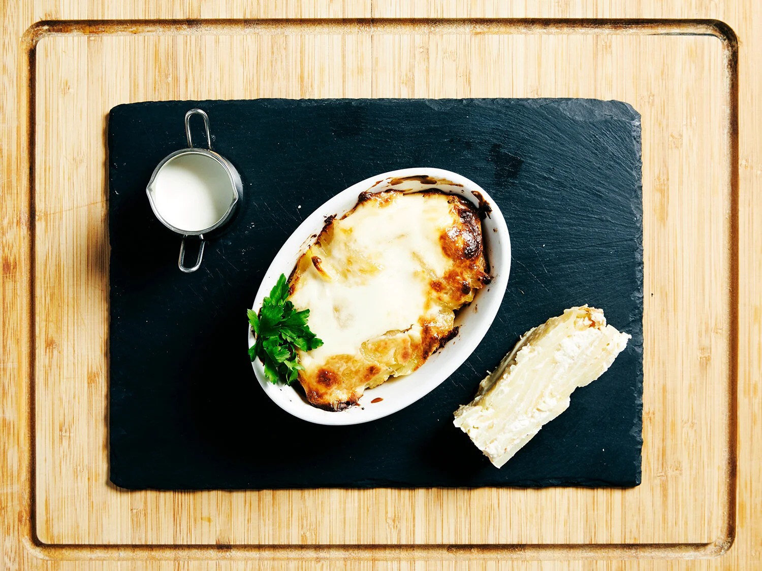 Potato Dauphinois served on a slate on a wooden board