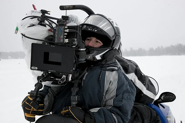 Kristina, shooting on the back of a snowmobile.