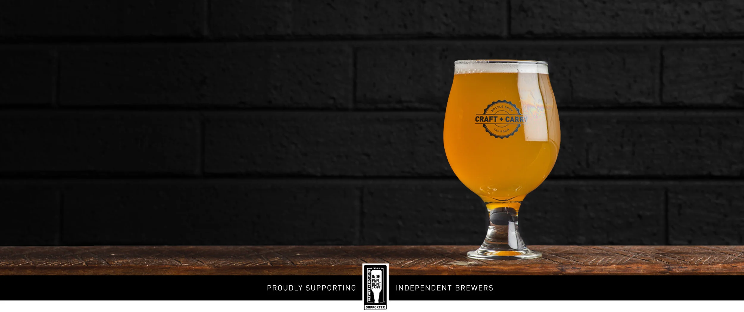 Glass of golden beer in a glass with the Craft+Carry logo.jpg