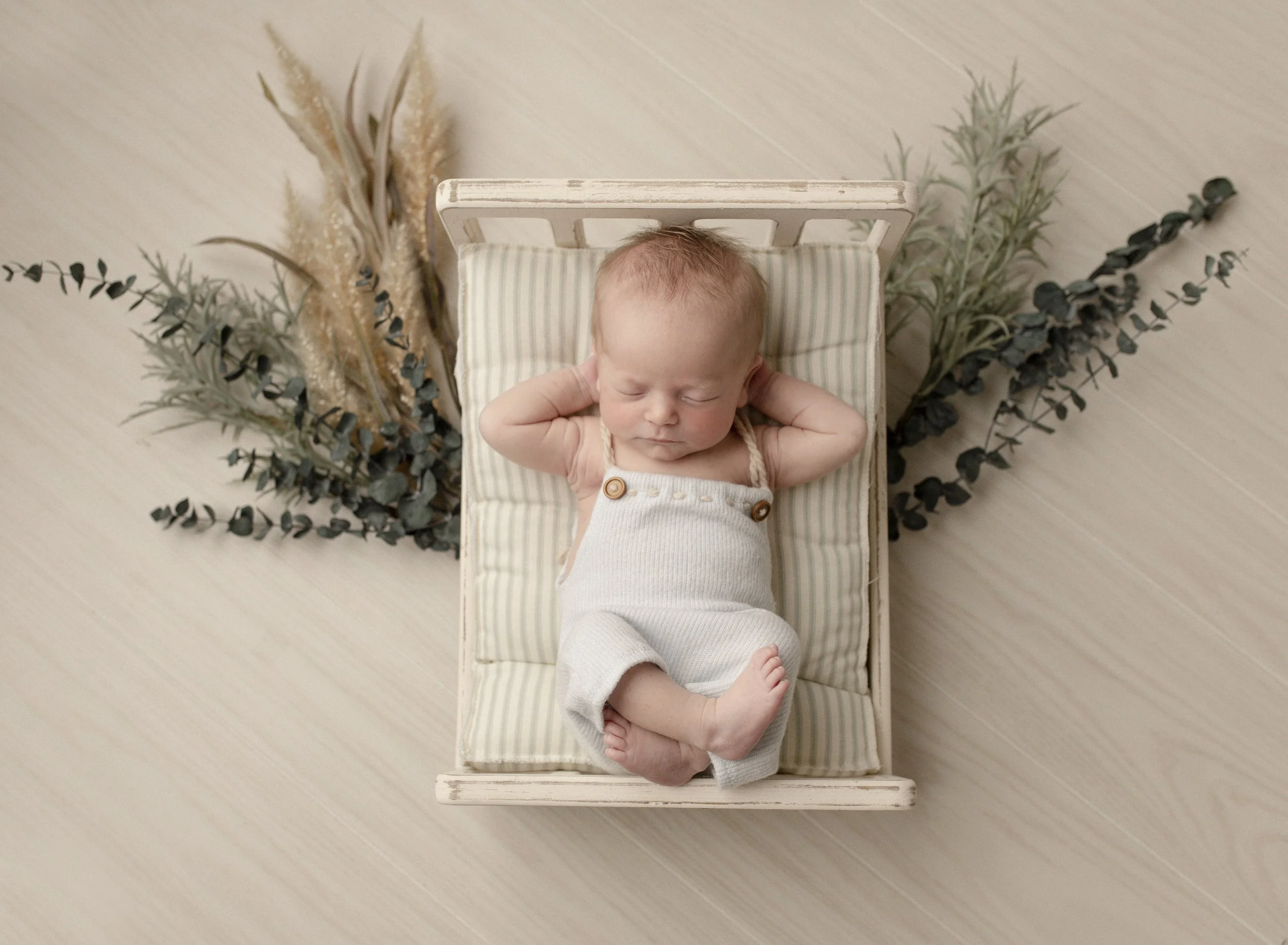 tiny-bed-with-newborn-wearing-overalls.jpg