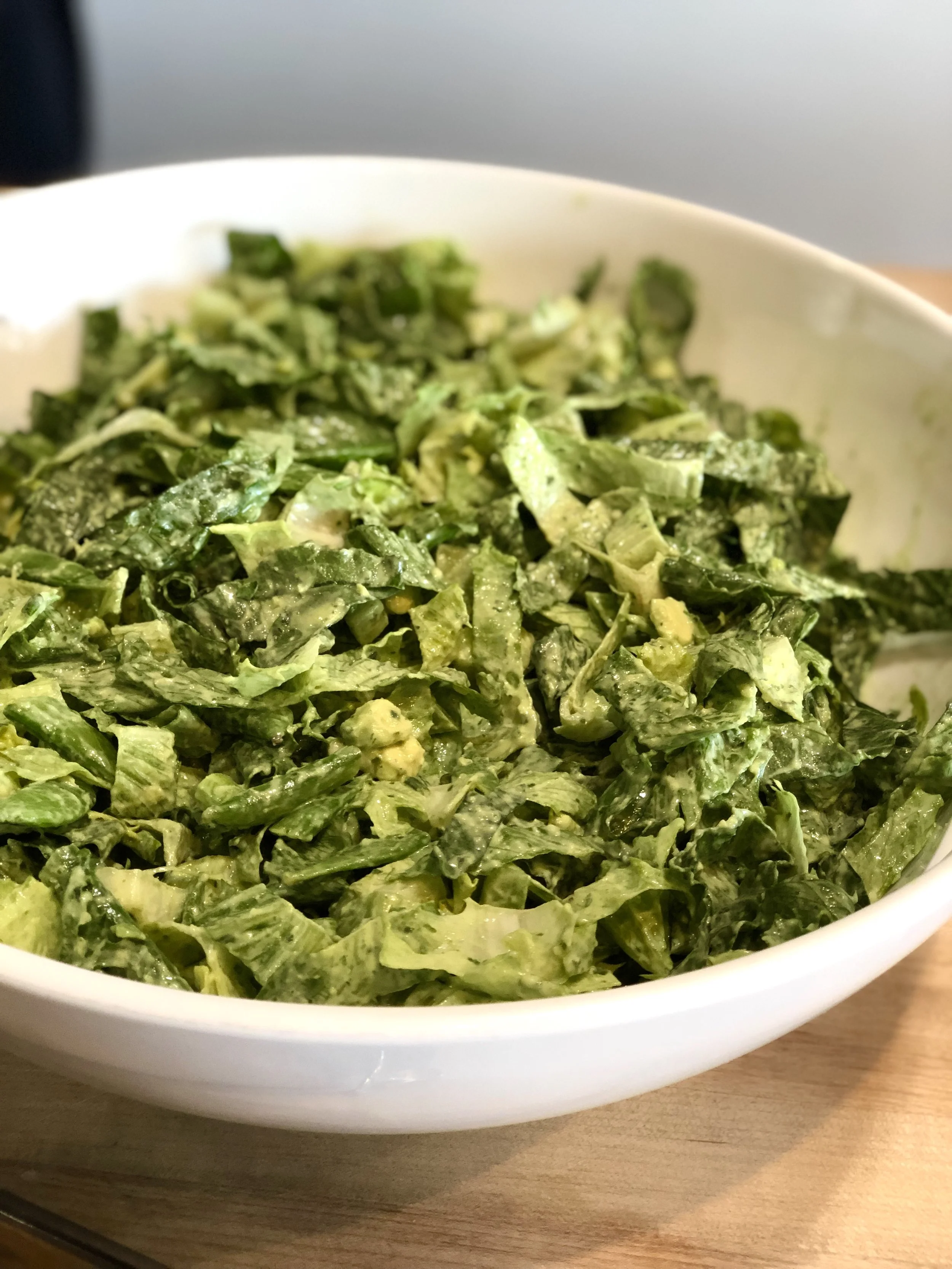 A Romaine Salad with Green Goddess Dressing Serves 4 to 6 Ingredients: 2 oil packed anchovy fillets ½ cup mayonnaise 1/3 cup full fat Greek yogurt ½ cup parsley leaves ¼ cup basil leaves ½ tsp Sariette Blend (roasted garlic, shallot and onion powder blend) 1 Tbl lemon juice, plus additional for seasoning 2 Tbl chopped fresh tarragon leaves 2 Tbl minced chives Salt and Pepper 2 cups snap peas 2 hearts of romaine lettuce, washed and chopped 1 seedless cucumber, diced 3 green onions, thinly sliced 1 avocado, cubed In a food processor combine the anchovy fillets, mayonnaise, yogurt, parsley, basil, Sariette Blend, and 1 Tbl lemon juice and process until smooth and brilliant green. Transfer to a bowl and stir in the tarragon and chives, and season to taste with salt and pepper, and additional lemon juice. Bring a medium saucepan of salted water to a boil over high heat. Add the snap peas and cook over high heat. Add the snap peas and cook until just tender, about 2 minutes. Drain in a colander and rinse with cold water until peas are cool. Transfer to a paper-towel lined sheet pan and roll up to get dry (the dressing won’t stick to a wet snap pea.) Cut each pea in half crosswise on the biasIn a large bowl, combine the snap peas, romaine, cucumbers, and green onions and mix well to combine. Add the avocado and about half the dressing (save the rest; it will keep, covered and refrigerated, for up to a week.) Mix gently with your hands until salad is well coated with dressing and season with salt and pepper.
